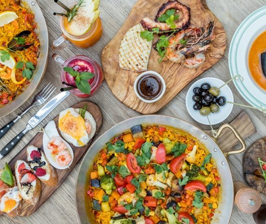 İspanyol mutfağı, Akdeniz ikliminin sunduğu bereketli tarım ürünleri ve tarih boyunca süregelen kültürel etkileşimlerle şekillenmiştir. Fenikelilerden Romalılara, Araplardan Yeni Dünya keşiflerine kadar uzanan süreç, mutfağın bugünkü zenginliğinin temelini oluşturur. Arap etkisi, özellikle baharatların, pirincin ve zeytinyağının mutfakta önemli bir yer edinmesini sağlamıştır. Konulu bir haber görseli.