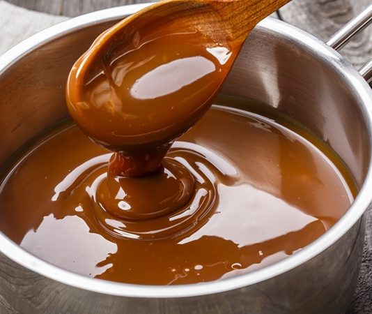 Karamel, tatlıların vazgeçilmez unsurlarından biridir ve mutfaklarda hem dekoratif hem de lezzet artırıcı bir rol oynar. Karamel pişirme süreci, şekerin kontrollü bir şekilde ısıtılması ve karamelize olması ile başlar. Bu yöntem sayesinde şekerin rengi altın kahverengiye dönüşür ve aroması yoğunlaşır. Konulu bir haber görseli.