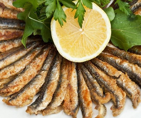 Hamsi, Türkiye’nin Karadeniz bölgesinin ve birçok sahil kentinin vazgeçilmez balığı olarak sofralarda özel bir yere sahiptir. Küçük boyutuna rağmen besin değeri yüksek olan hamsi, özellikle sonbahar ve kış aylarında bolca tüketilir. Hem ekonomik olması hem de kendine has lezzetiyle hamsi, evlerde, balık lokantalarında ve hatta sokak tezgâhlarında sıkça karşımıza çıkar. Sofralarda hamsi, kültürel bir simge olarak da kabul edilir. Konulu bir haber görseli.