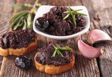 Tapenade, özellikle Fransız ve Akdeniz mutfağının vazgeçilmez zeytin ezmesi olarak biliniyor. Temel malzemeleri arasında siyah zeytin, kapari, zeytinyağı ve bazen ançüez bulunuyor. Bu malzemeler mutfak robotunda püre haline getirilerek homojen bir kıvam elde ediliyor. Hazırlanışı oldukça basit olsa da, malzemelerin kalitesi ve tazeliği ezmenin lezzetini doğrudan etkiliyor. Konulu bir haber görseli.