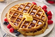 Waffle, özellikle kahvaltı ve tatlı sofralarının vazgeçilmez lezzetlerinden biri olarak biliniyor. İnce ve çıtır hamuru, kareli yapısı ve çeşitli soslarla sunulmasıyla sofralarda estetik bir görünüm oluşturuyor. Tarihsel olarak Avrupa kökenli olan waffle, zaman içinde Amerika ve Türkiye’de de yaygın bir tatlı ve atıştırmalık haline gelmiştir. Konulu bir haber görseli.