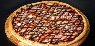 Barbekü pizza, klasik İtalyan pizzalarının modern yorumlarından biri olarak öne çıkar. Barbekü sosu kullanımı, pizzaya özgün bir tat ve aroma katarak farklı bir lezzet deneyimi sunar. İlk olarak Amerika’da ortaya çıkan barbekü pizzası, kısa sürede dünya genelinde popülerlik kazanmıştır. Konulu bir haber görseli.