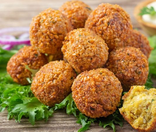 Falafel: Orta Doğu’nun Lezzetli Atıştırmalığı Falafel, Orta Doğu mutfağının en bilinen ve sevilen lezzetlerinden biridir. Nohut veya bakla bazlı olarak hazırlanan bu kızartılmış toplar, hem vejetaryenler hem de et severler için sağlıklı bir alternatif sunar. Baharatlar ve taze otlarla zenginleştirilen falafel, çıtır dış yüzeyi ve yumuşak iç dokusuyla damaklarda unutulmaz bir tat bırakır. Bu yazımızda falafel tarifinden tarihçesine, hazırlık aşamalarından sunum önerilerine kadar detaylı bilgiler bulabilirsiniz. Konulu bir haber görseli.
