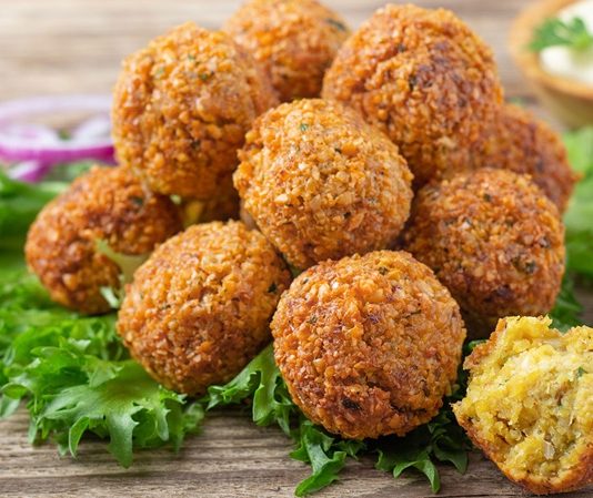 Ortadoğu mutfağının en bilinen ve sevilen lezzetlerinden biri olan Falafel, nohut veya bakla gibi baklagillerden yapılan küçük, yuvarlak köftelerdir. Baharatlarla zenginleştirilen bu karışım, kızartılarak ya da fırında pişirilerek servis edilir. Falafel, hem doyurucu hem de besleyici bir seçenek olarak öne çıkar. Konulu bir haber görseli.