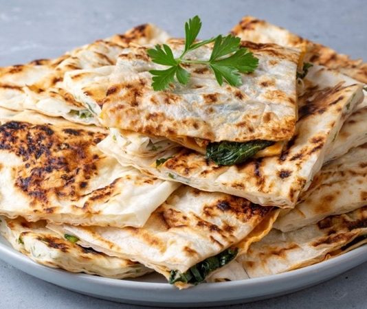 Gözleme Türk Mutfağının Vazgeçilmez Lezzeti Türk mutfağının en sevilen hamur işi lezzetlerinden biri olan gözleme, geçmişten günümüze gelen bir miras olarak sofralarda yerini koruyor. Yüzyıllardır Anadolu’da farklı bölgelerde yapılan gözleme, her yörenin kendine özgü tarifleriyle çeşitlilik kazanıyor. İnce açılmış hamurun arasına konulan farklı iç harçlarıyla hazırlanan bu lezzet, sadece Türkiye’de değil, dünyada da giderek daha çok tanınmaya başlıyor. Özellikle turistlerin ilgisini çeken gözleme, geleneksel Türk kahvaltılarının ve sokak lezzetlerinin ayrılmaz bir parçası haline geldi. Konulu bir haber görseli.