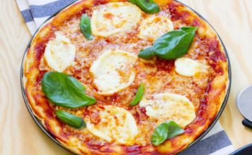 Margarita Pizza: Klasik İtalyan Lezzetinin Sofralardaki Yükselişi Margarita pizza, İtalyan mutfağının en ikonik lezzetlerinden biri olarak bilinir. Napoli kökenli bu pizza türü, basit ama dengeli malzemeleriyle ün kazanmıştır. Domates, mozzarella peyniri ve taze fesleğen kullanımı, pizzanın üç temel rengi olan kırmızı, beyaz ve yeşili simgeler. Konulu bir haber görseli.