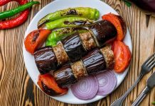 Türk mutfağının vazgeçilmez lezzetlerinden biri olan patlıcan kebabı, özellikle Gaziantep, Şanlıurfa ve Adana gibi şehirlerde sıkça hazırlanır. Patlıcanın közlenip etle buluşmasıyla ortaya çıkan bu yemek, hem hafif hem de doyurucu bir öğün sunar. Osmanlı mutfağından günümüze uzanan tarif, yöresel farklılıklarla her sofrada kendine özgü bir tat bırakır. Konulu bir haber görseli.