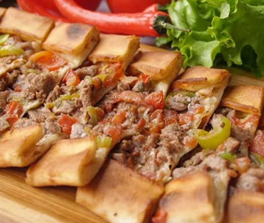 Türk mutfağının en özel hamur işleri arasında yer alan pide, yüzyıllar boyunca Anadolu’nun farklı bölgelerinde şekillenerek günümüze ulaşmıştır. İnce ya da kalın açılan hamurun üzerine kıyma, peynir, sucuk ya da sebzelerle hazırlanan malzemelerin eklenmesiyle pişirilen pide, hem doyurucu hem de lezzetli bir yiyecek olarak sofralarda yer alır. Osmanlı mutfak kültüründen izler taşıyan pide, özellikle taş fırınlarda pişirildiğinde kendine has aromasını bulur. Konulu bir haber görseli.