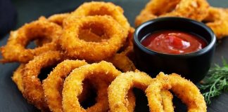 Soğan Halkası: Atıştırmalık Lezzetlerin Vazgeçilmezi Soğan halkası, fast food kültürünün en sevilen atıştırmalıklarından biri olarak öne çıkıyor. Tarihi 20. yüzyılın ortalarına dayanan bu lezzet, özellikle Amerika’da popülerlik kazanmış ve kısa sürede dünya mutfaklarına yayılmıştır. Patates kızartmaları ve burgerlerin yanında ikincil lezzet olarak sunulan soğan halkaları, hem çıtır dokusu hem de tatlımsı soğan aroması ile dikkat çekiyor. Konulu bir haber görseli.