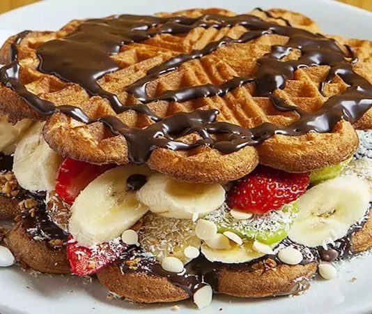 Waffle, Belçika kökenli, çıtır dışı ve yumuşak içi ile bilinen tatlı hamur ürünüdür. Orta Çağ’dan bu yana Avrupa’da tüketilen bu lezzet, zamanla Amerika ve diğer kıtalara yayılmıştır. Geleneksel olarak kahvaltıda veya tatlı saatlerinde tercih edilen waffle, taze meyve, çikolata veya karamel sosla servis edilir. Konulu bir haber görseli.