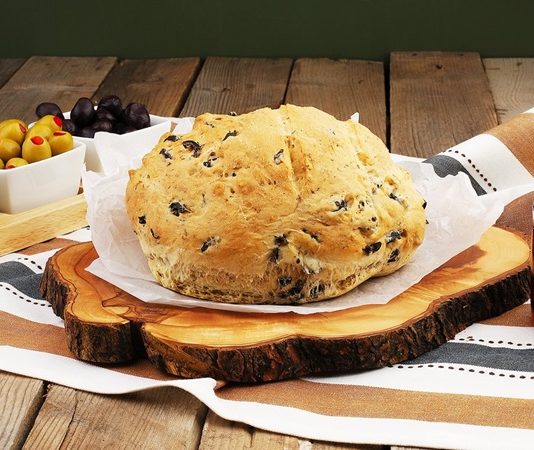 Geleneksel mutfaklarımızın vazgeçilmezlerinden biri olan zeytinli ekmek, hem kahvaltılarda hem de akşam yemeklerinde sofraları süsleyen özel bir lezzettir. Zeytinin doğal aroması ile ekmeğin yumuşak dokusunun birleşmesi, bu ürünü hem sağlıklı hem de lezzetli kılar. Ülkemizde özellikle Ege ve Akdeniz bölgelerinde uzun yıllardır tüketilen zeytinli ekmek, bölgesel tariflerle farklılıklar gösterir ve her sofraya özgün bir tat katar. Konulu bir haber görseli.