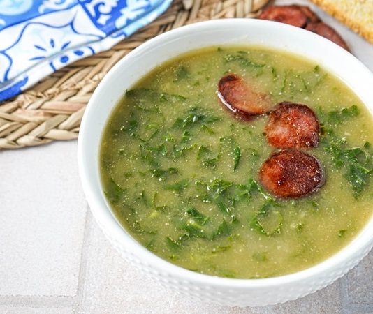 Portekiz mutfağının en sevilen geleneksel çorbalarından biri olan Caldo Verde, sade malzemelerle büyük bir lezzet sunmasıyla biliniyor. Hem doyurucu hem besleyici olması sayesinde sadece Portekiz’de değil, dünyanın farklı mutfaklarında da ilgi görmeye başlayan bu özel çorba, özellikle son yıllarda gastronomi meraklılarının dikkatini çekiyor. Yumuşacık dokusu, hafif dumanlı aroması ve ferahlatıcı bitkisel tadıyla Caldo Verde, gastronomik açıdan kültürel bir miras niteliği taşıyor. Konulu bir haber görseli.