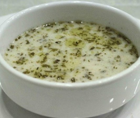 Türk mutfağının vazgeçilmez çorbalarından biri olan yoğurt çorbası, hem yaz hem de kış sofralarında kendine özel bir yer edinmiş durumda. Yoğurt, un ve bazen pirinç ya da buğday kullanılarak hazırlanan bu çorba, hem besleyici hem de ferahlatıcı özelliğiyle dikkat çekiyor. Özellikle sindirimi kolaylaştırması ve vücuda enerji vermesi nedeniyle birçok aile tarafından tercih ediliyor. Yoğurt çorbası, yıllardır Türk mutfağında nesilden nesile aktarılan bir lezzet olarak kültürel bir miras niteliği taşıyor. Konulu bir haber görseli.