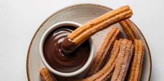 Churros Lezzetinin Yükselen Popülaritesi Tatlı Dünyasında Yeni Bir Dönem Churros, son yıllarda yalnızca İspanya’nın geleneksel sokak lezzeti olmaktan çıkıp dünya genelinde kafe menülerinin favorisi haline geldi. Özellikle Türkiye’de tatlı kültürünün giderek çeşitlenmesiyle birlikte churros popüler bir alternatif olarak öne çıkıyor. Çıtır yapısı, şeker ve tarçınla kaplanan dış yüzeyi ve sıcak çikolata sosuyla birleştiğinde ortaya çıkan benzersiz tat, birçok insanın yeni gözdesi haline gelmiş durumda. Konulu bir haber görseli.