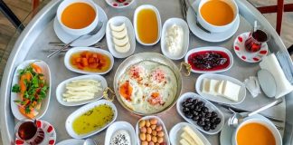 Anadolu’nun en güçlü kültürel sembollerinden biri olan köy sofrası, yalnızca yemek yenen bir alan değil; paylaşmanın, dayanışmanın ve doğallığın somutlaştığı bir yaşam pratiğidir. Toprakla iç içe bir hayatın ürünü olan bu sofralar, mevsimin sunduğu nimetleri ve emeğin karşılığını bir araya getirir. Köy sofrasında gösterişten çok samimiyet, çeşitlilikten çok bereket ön plandadır. Bu nedenle köy sofrası, şehir hayatında giderek özlenen bir değer hâline gelmiştir. Konulu bir haber görseli.