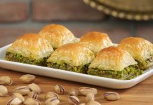 Türkiye’nin en özel tatlılarından biri olan baklava, yüzyıllar boyunca hem coğrafyalara hem de kültürlere yayılan zengin bir mirasa sahip. Orta Asya’dan Anadolu’ya uzanan serüveniyle bugün dünyanın dört bir yanında tanınan bir lezzet hâline gelen baklava, Osmanlı mutfağından itibaren saray sofralarının vazgeçilmez tatlısı olarak kayıt altına alınmıştır. Bu süreçte tatlının yapım teknikleri geliştirilmiş, farklı yörelerde kendine has çeşitleri ortaya çıkmıştır. Gaziantep baklavası, bu tarihsel yolculukta en çok bilinen ve coğrafi işaret tesciline sahip örneklerden biridir. Konulu bir haber görseli.