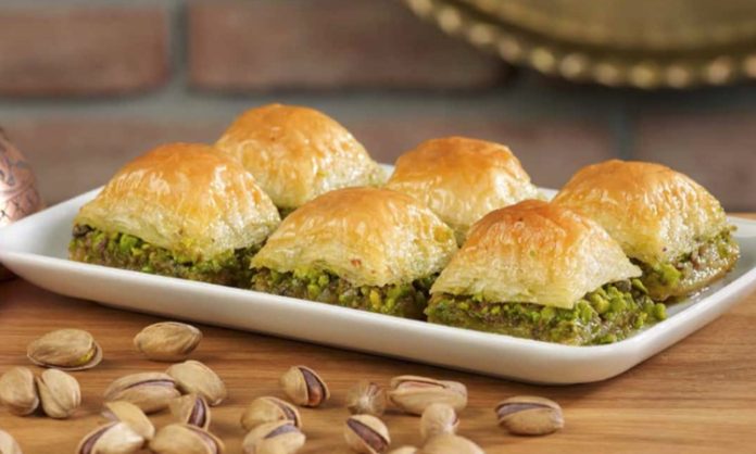 Geleneksel Lezzet Baklavanın Yükselen Popülaritesi ve Modern Dokunuşlarla Yeniden Şekillenen Yolculuğu Türkiye’nin en özel tatlılarından biri olan baklava, yüzyıllar boyunca hem coğrafyalara hem de kültürlere yayılan zengin bir mirasa sahip. Orta Asya’dan Anadolu’ya uzanan serüveniyle bugün dünyanın dört bir yanında tanınan bir lezzet hâline gelen baklava, Osmanlı mutfağından itibaren saray sofralarının vazgeçilmez tatlısı olarak kayıt altına alınmıştır. Bu süreçte tatlının yapım teknikleri geliştirilmiş, farklı yörelerde kendine has çeşitleri ortaya çıkmıştır. Gaziantep baklavası, bu tarihsel yolculukta en çok bilinen ve coğrafi işaret tesciline sahip örneklerden biridir. Konulu bir haber görseli.