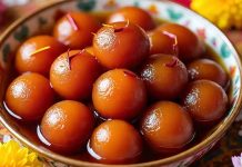 Hindistan’ın en sevilen tatlılarından biri olan Gulab Jamun, son yıllarda sadece Güney Asya’da değil dünya genelinde tatlı severlerin dikkatini çekmeye devam ediyor. Paylaşılan videolar, sokak lezzeti kültürü ve uluslararası restoran zincirlerinin menülerine eklemesi sayesinde gulab jamun, küresel gastronomide kendine daha fazla yer edinmeye başladı. Geleneksel hazırlama yöntemi, yoğun kıvamlı şerbeti ve kendine özgü baharat aromalarıyla öne çıkan tatlı, şimdilerde Batı ülkelerinde bile aranan tatlar arasına girdi. Konulu bir haber görseli.