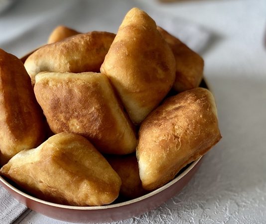 Sokaklardan Sofralara Uzanan Bir Lezzet Pişi Günü Türk mutfağının en sade ama en sevilen hamur işlerinden biri olan pişi, son yıllarda özel günlerle anılarak yeniden gündeme geliyor. Pişi Günü, hem geleneksel lezzetleri hatırlatma hem de toplumsal paylaşımı artırma amacı taşıyan anlamlı bir gün olarak öne çıkıyor. Sabah kahvaltılarından hayır etkinliklerine kadar uzanan geniş bir kullanım alanına sahip olan pişi, kültürel hafızada önemli bir yere sahip. Konulu bir haber görseli