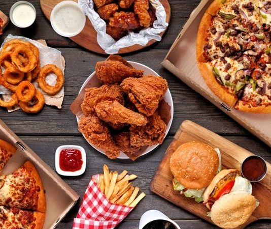 Fast food zincirleri, modern şehir yaşamının hızına uyum sağlayan en belirgin yeme içme modellerinden biri olarak öne çıkıyor. Kısa sürede hazırlanabilen menüler, standart lezzet anlayışı ve ulaşılabilir fiyat politikaları sayesinde bu restoranlar, dünyanın hemen her köşesinde geniş bir müşteri kitlesine hitap ediyor. Günümüzde fast food zincirleri, yalnızca pratik bir yemek seçeneği olmanın ötesine geçerek küresel tüketim kültürünün önemli bir parçası hâline gelmiş durumda. Konulu bir haber görseli.