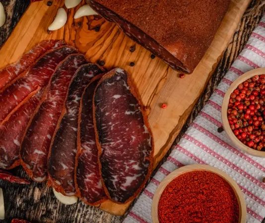 Kuru et ve pastırma, yüzyıllardır farklı coğrafyalarda tüketilen ve özellikle Anadolu mutfağında önemli bir yere sahip olan geleneksel et ürünleri arasında bulunuyor. Dayanıklılığı, yoğun aroması ve uzun süre saklanabilme özelliği sayesinde kuru et ve pastırma, hem geçmişte hem de günümüzde sofraların vazgeçilmezleri arasında yer alıyor. Modern üretim teknikleri gelişmiş olsa da bu ürünlerin temelinde hâlâ geleneksel yöntemler ve ustalık bilgisi bulunuyor. Konulu bir haber görseli.