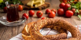 Türkiye’de sokak lezzetleri denildiğinde akla gelen ilk tatlar arasında simit ve açma yer alır. Günün her saatinde ulaşılabilen bu iki hamur işi, yalnızca pratik bir atıştırmalık olmanın ötesinde, şehir yaşamının ritmini belirleyen önemli unsurlardan biri olarak görülür. Sabah işe yetişmeye çalışan bir memurun elinde, okul yolunda koşan bir öğrencinin çantasında ya da sahil kenarında çay eşliğinde tüketilen bu lezzetler, toplumsal hafızanın da güçlü bir parçasıdır. Konulu bir haber görseli.